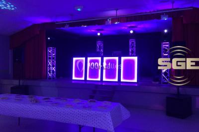 Installation de matériel de sonorisation et d'éclairage sous une tente, avec une table de mixage et des projecteurs.