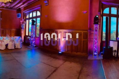 Installation de matériel de sonorisation et d'éclairage sous une tente, avec une table de mixage et des projecteurs.