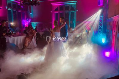 Installation de matériel de sonorisation et d'éclairage sous une tente, avec une table de mixage et des projecteurs.