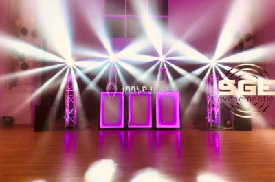 Installation de matériel de sonorisation et d'éclairage sous une tente, avec une table de mixage et des projecteurs.