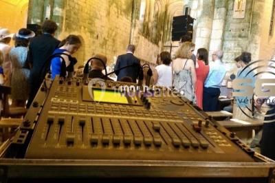 Installation de matériel de sonorisation et d'éclairage sous une tente, avec une table de mixage et des projecteurs.