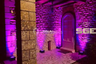 Installation de matériel de sonorisation et d'éclairage sous une tente, avec une table de mixage et des projecteurs.