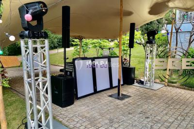 Installation de matériel de sonorisation et d'éclairage sous une tente, avec une table de mixage et des projecteurs.