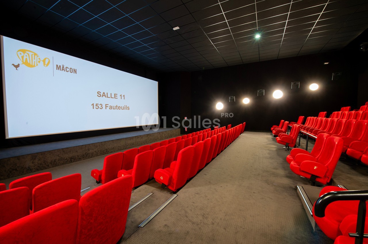 Salle de cinéma vide avec des rangées de fauteuils rouges et un écran affichant ’Salle 11 - 153 fauteuils’.