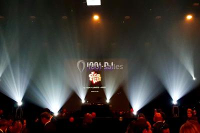 Un couple danse au milieu d'une piste entourée de fumée, tandis qu'un musicien joue du saxophone en avant-plan.