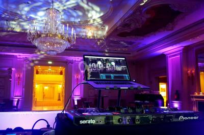 Un couple danse au milieu d'une piste entourée de fumée, tandis qu'un musicien joue du saxophone en avant-plan.