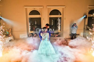 Un couple danse au milieu d'une piste entourée de fumée, tandis qu'un musicien joue du saxophone en avant-plan.