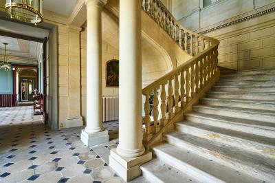 Miniature Château des Deux Lions - Escalier accès 1er étage (sans ascenseur) Salle élégante avec parquet en bois, murs ornés de moulures, lustres et mobilier classique.