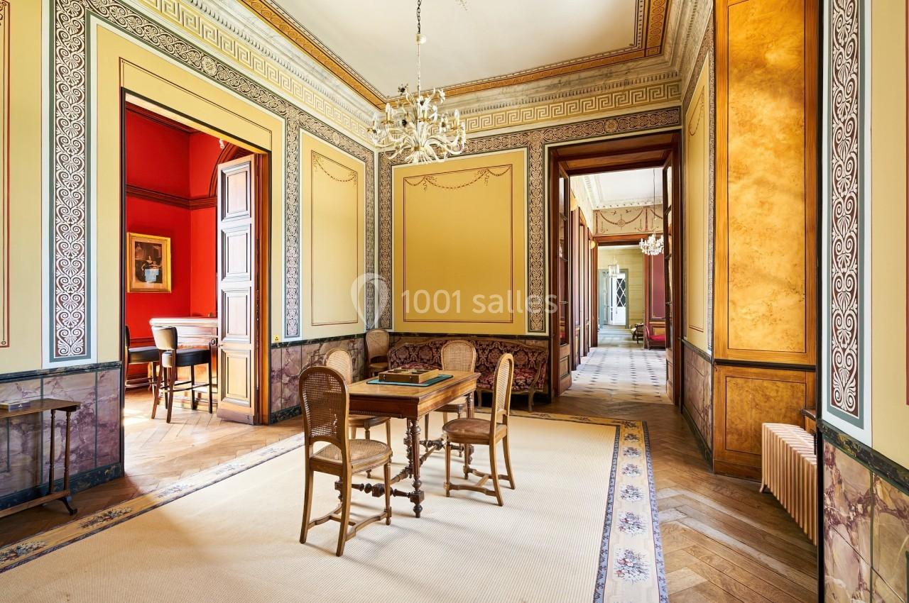 Château des Deux Lions - Salle de jeu, espace atelier 1er étage Salle élégante avec parquet en bois, murs ornés de moulures, lustres et mobilier classique.