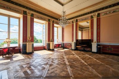 Miniature Château des Deux Lions - Salon magistral (partie restauration ou réunion avec écran) Salle élégante avec parquet en bois, murs ornés de moulures, lustres et mobilier classique.