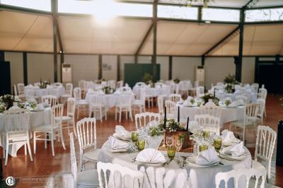Salle de réception éclairée la nuit, avec des tables dressées visibles à travers les baies vitrées.