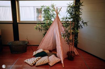 Salle de réception éclairée la nuit, avec des tables dressées visibles à travers les baies vitrées.