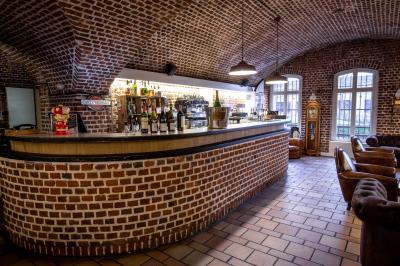 Miniature Location salle Mons-en-Baroeul (Nord) - Fort de Mons #11 Salle de restaurant avec murs en briques, bar éclairé en arrière-plan et table dressée au premier plan.