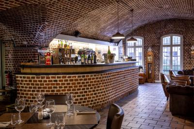 Miniature Location salle Mons-en-Baroeul (Nord) - Fort de Mons #7 Salle de restaurant avec murs en briques, bar éclairé en arrière-plan et table dressée au premier plan.