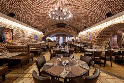 Miniature Location salle Mons-en-Baroeul (Nord) - Fort de Mons #3 Salle de restaurant avec murs en briques, bar éclairé en arrière-plan et table dressée au premier plan.