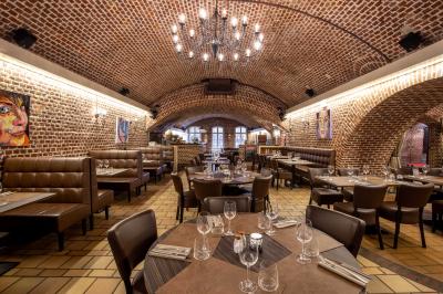 Miniature Location salle Mons-en-Baroeul (Nord) - Fort de Mons #5 Salle de restaurant avec murs en briques, bar éclairé en arrière-plan et table dressée au premier plan.