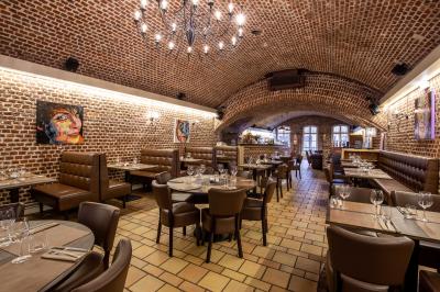 Miniature Location salle Mons-en-Baroeul (Nord) - Fort de Mons #4 Salle de restaurant avec murs en briques, bar éclairé en arrière-plan et table dressée au premier plan.