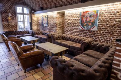 Miniature Location salle Mons-en-Baroeul (Nord) - Fort de Mons #8 Salle de restaurant avec murs en briques, bar éclairé en arrière-plan et table dressée au premier plan.