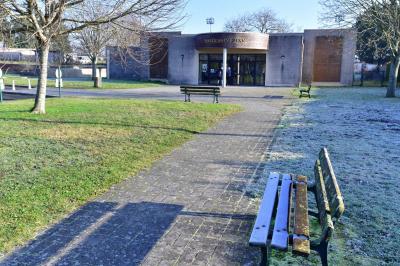 Cuisine professionnelle avec plan de travail en inox, cuisinière, évier, hotte et équipements muraux dans un espace carrelé.