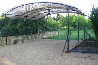 Des personnes assises sur des tapis et des chaises dans une salle lumineuse avec un tableau et des rideaux.