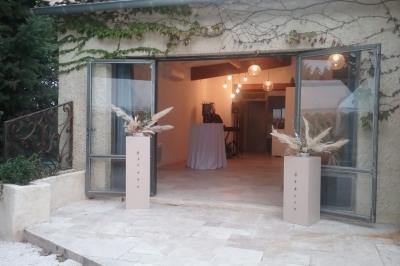Des personnes assises sur des tapis et des chaises dans une salle lumineuse avec un tableau et des rideaux.