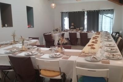 Des personnes assises sur des tapis et des chaises dans une salle lumineuse avec un tableau et des rideaux.