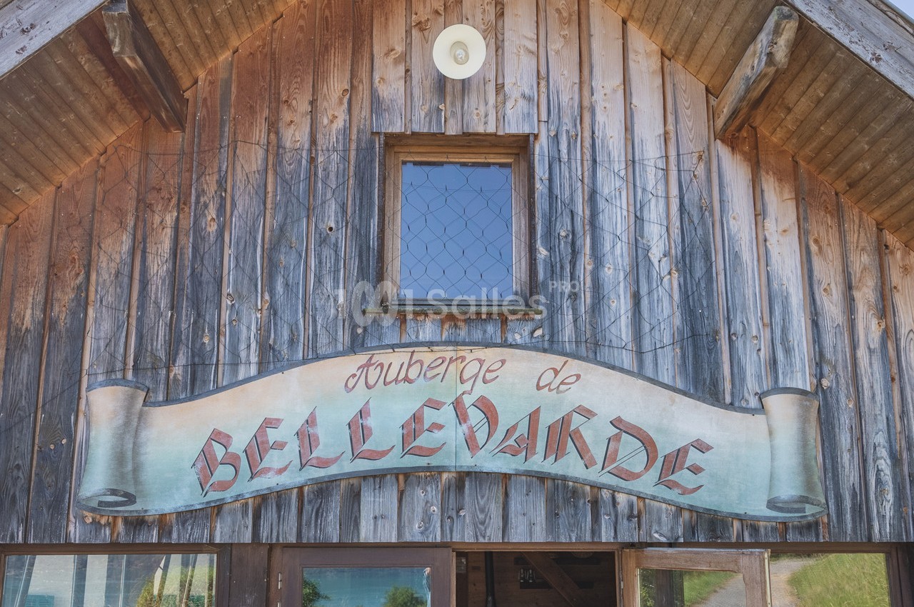 Façade en bois d'une auberge avec une enseigne indiquant ’Auberge de Bellevarde’.