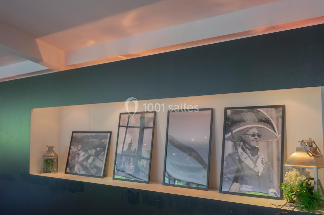 Quatre cadres photo alignés sur une étagère, éclairés par une lumière douce, avec des objets décoratifs autour.