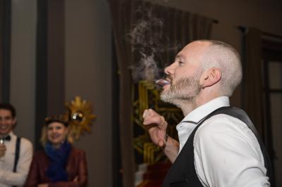 Un groupe de personnes assises et debout, riant et échangeant lors d'un moment convivial en extérieur.