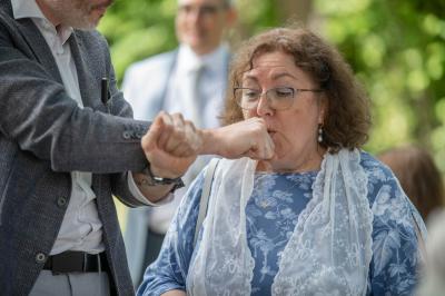 Un groupe de personnes assises et debout, riant et échangeant lors d'un moment convivial en extérieur.