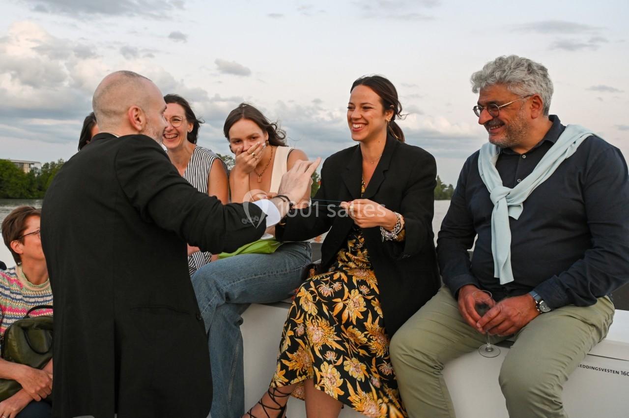 Un groupe de personnes assises à l'extérieur, souriant et échangeant lors d'un moment convivial en fin de journée.