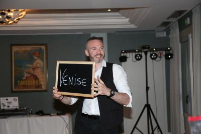 Un groupe de personnes assises et debout, riant et échangeant lors d'un moment convivial en extérieur.
