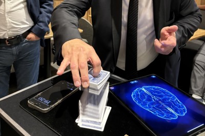 Miniature Martial Magicien Digital Mentaliste #13 Un homme en costume verse une boisson depuis une tablette numérique dans un verre, illustrant un effet magique.