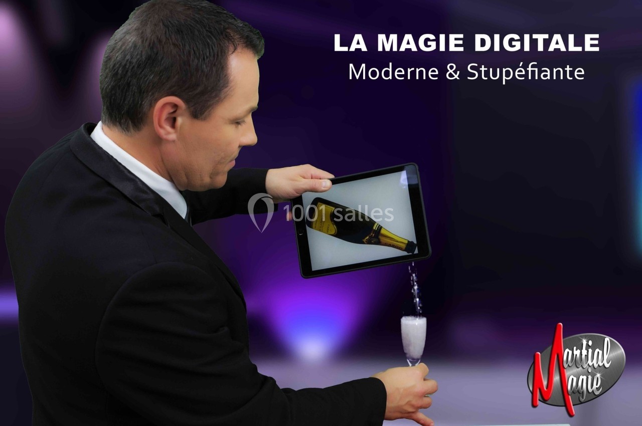 Un homme en costume verse une boisson depuis une tablette numérique dans un verre, illustrant un effet magique.