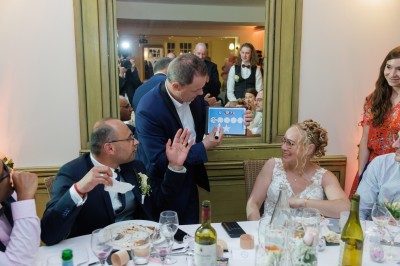 Miniature Martial Magicien Digital Mentaliste #10 Un homme en costume verse une boisson depuis une tablette numérique dans un verre, illustrant un effet magique.