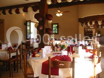 Salle de réception décorée avec des ballons rouges et blancs, tables dressées avec nappes blanches et serviettes rouges.