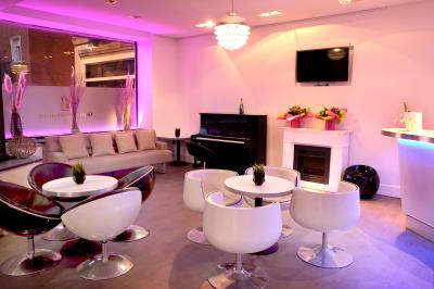 Entrée éclairée d'un casino avec enseigne lumineuse, sol coloré et portes vitrées donnant sur l'intérieur.