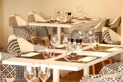 Entrée éclairée d'un casino avec enseigne lumineuse, sol coloré et portes vitrées donnant sur l'intérieur.
