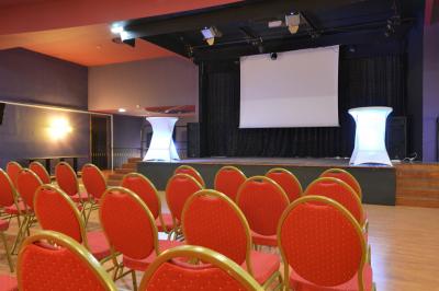 Entrée éclairée d'un casino avec enseigne lumineuse, sol coloré et portes vitrées donnant sur l'intérieur.