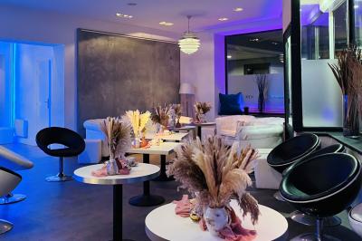 Entrée éclairée d'un casino avec enseigne lumineuse, sol coloré et portes vitrées donnant sur l'intérieur.