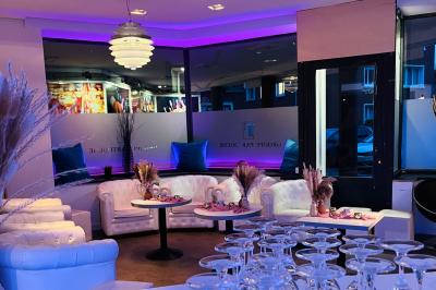 Entrée éclairée d'un casino avec enseigne lumineuse, sol coloré et portes vitrées donnant sur l'intérieur.