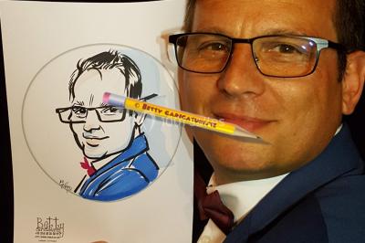 Un petit chien tenu dans les bras, à côté d'un dessin caricatural le représentant.