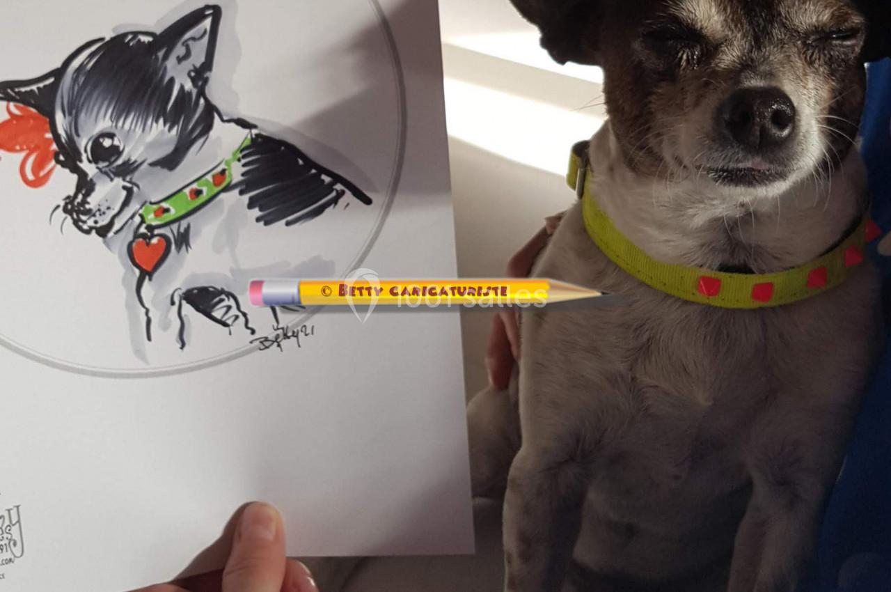Un petit chien tenu dans les bras, à côté d'un dessin caricatural le représentant.