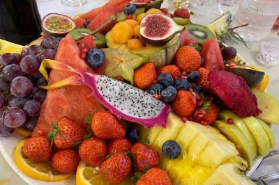 Table dressée avec une assiette blanche, un cadeau doré, une serviette beige nouée et des macarons en décoration.