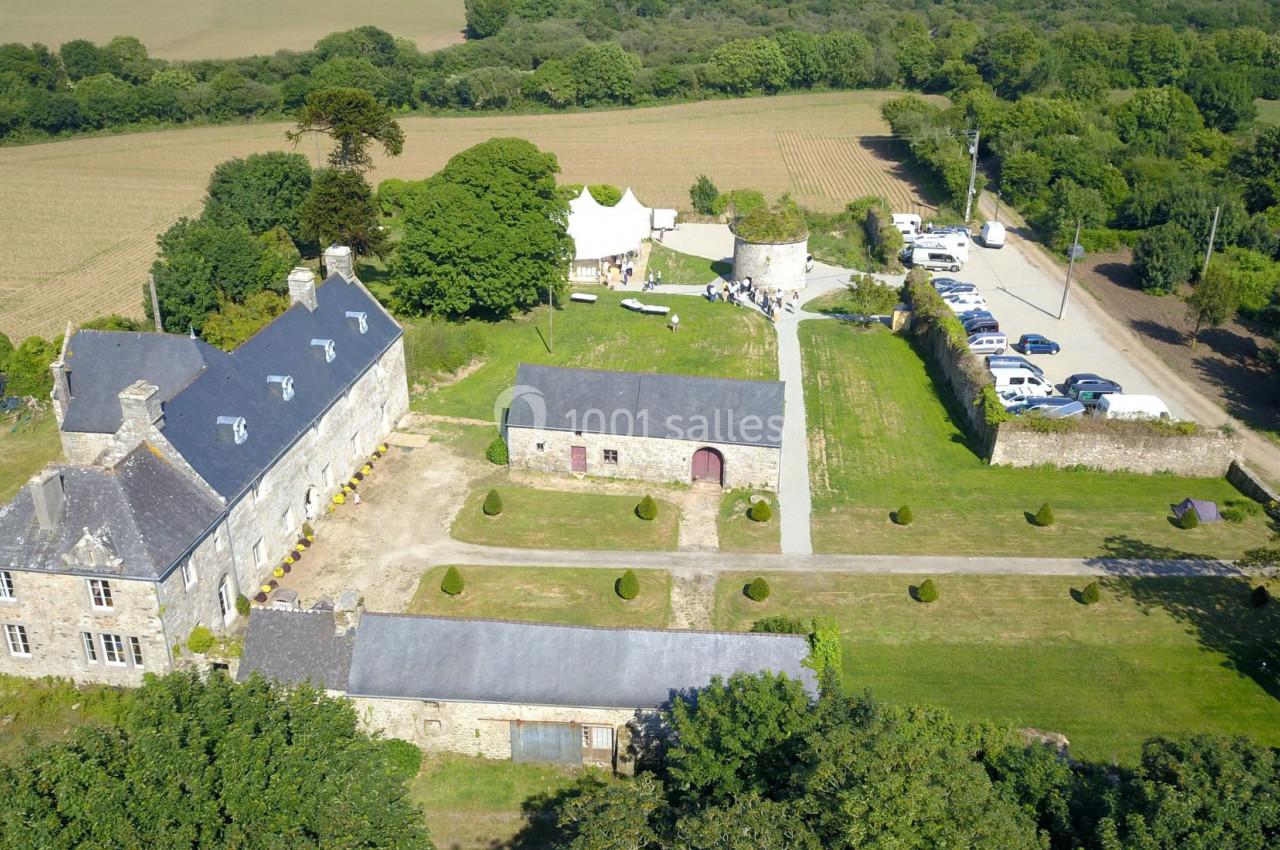 Vue aérienne d'un domaine rural avec bâtiments en pierre, cour centrale, pelouses et parking à proximité.