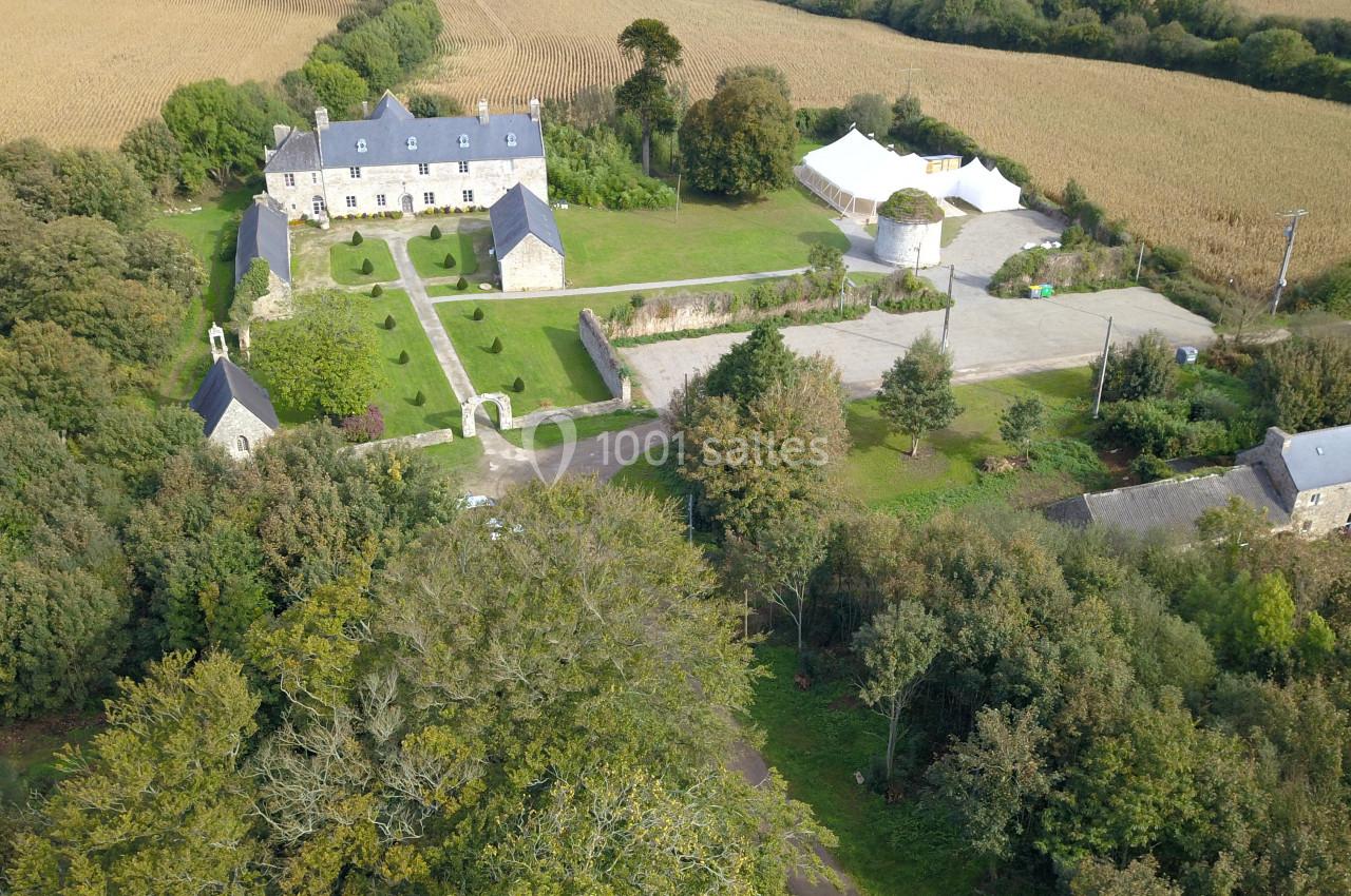 Vue aérienne d'un domaine rural avec bâtiments en pierre, jardin aménagé, cour et champs environnants.