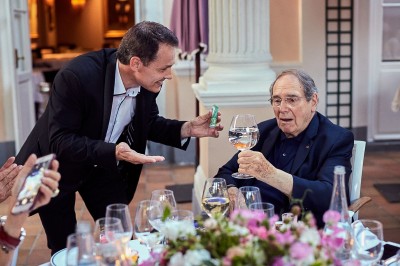 Miniature Martial Magicien Digital Mentaliste #10 Un homme en costume tenant une tablette affichant des applications, avec un smartphone placé devant l'écran.