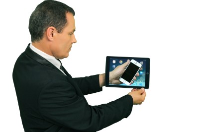 Miniature Martial Magicien Digital Mentaliste #15 Un homme en costume tenant une tablette affichant des applications, avec un smartphone placé devant l'écran.