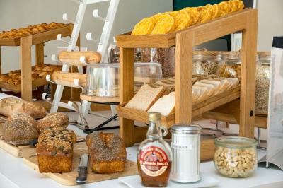 Miniature Location salle Orgeval (Yvelines) - Novotel Poissy Orgeval #9 Buffet de petit-déjeuner avec œufs, saucisses, bacon et ustensiles disposés sur un comptoir blanc.