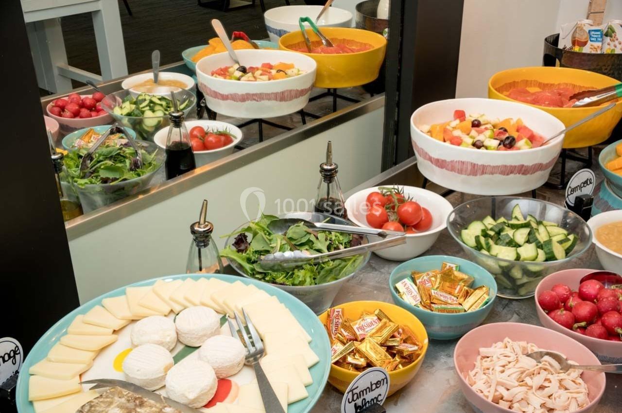 Location salle Orgeval (Yvelines) - Novotel Poissy Orgeval #10 Buffet avec salades, légumes frais, fromages, charcuterie et condiments disposés dans des bols colorés.